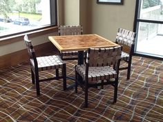 a dining room table and chairs in front of a window