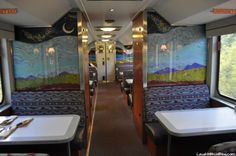 the inside of a train car with tables and benches