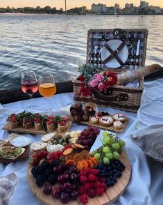 a table topped with lots of different types of food and wine glasses on top of it