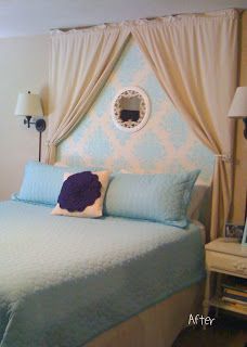 a blue and white bed with curtains on the headboard is in front of a window