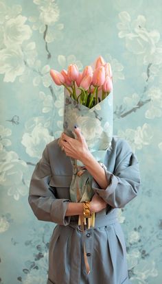 a woman holding a bouquet of pink tulips