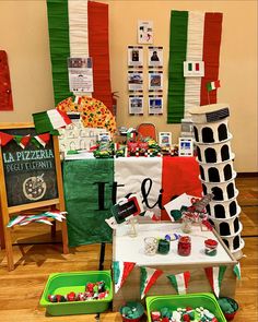 the table is set up for an italian themed party with lots of food and decorations