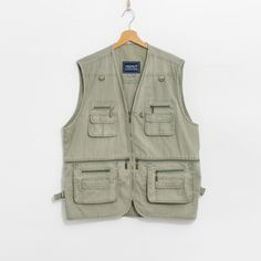 Vintage 90's utility vest in khaki-green - with a front zip - 4 main and few smaller pockets - materials: 65% cotton, 35% poliester SIZE: XL MEASUREMENTS chest: 49 inches (125 cm) length: 30 inches (76 cm) CONDITION - 8/10 - The vest in good vintage condition. Washed, ready to wear. Spring Utility Vest With Pockets, Functional Cotton Vest For Spring, Functional Spring Vest With Pockets, Spring Functional Vest With Pockets, Spring Functional Cotton Vest, Sleeveless Utility Outerwear With Pockets, Utility Streetwear Vest With Patch Pockets, Utility Vest With Patch Pockets For Streetwear, Summer Streetwear Vest With Pockets