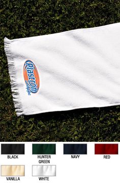 a white towel laying on top of green grass with the words, wisconsin in blue and orange