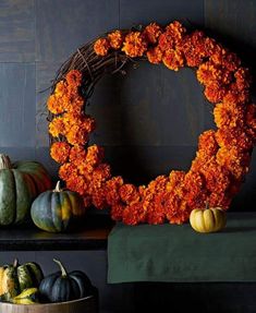 pumpkins and gourds are arranged around a wreath