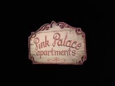 pink palace apartments sign lit up in the dark