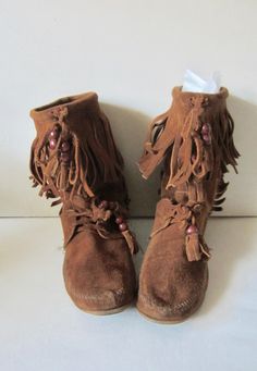 Vintage Minnetonka Moccasins! Brown suede boots Lace boots with fringes Unisex Minnetonka Moccasins Size 7 - 7.5  A comfortable pair of soft leather boots Soft crepe soles. They are in great vintage condition.  Minor light wear Size: 7 (marked) Heel to toe: 10" Wide 3.10" High: 9" **Note: these kind of shoes usually can fits more 1/2 size Bohemian Suede Boots With Tassels, Bohemian Brown Suede Boots, Festival Boots With Tassels And Round Toe, Bohemian Suede Boots With Fringe, Bohemian Suede Fringe Boots, Bohemian Style Fringe Suede Boots, Brown Tasseled Boots For Festivals, Festival Leather Fringe Boots, Brown Fringe Boots For Festival