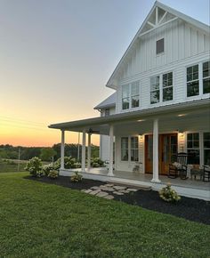 a large white house sitting on top of a lush green field