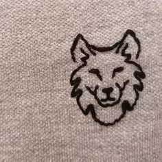 an embroidered wolf head on the back of a sweater