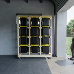 a man standing in front of a storage unit with bins on it's sides