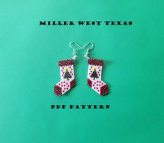 a pair of red and white beaded christmas stocking earrings on a green background