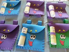 four purple and green paper bags with faces on them