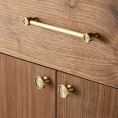 a close up of a wooden cabinet with brass handles