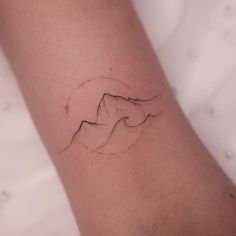 a woman's arm with a mountain tattoo on the left side of her arm