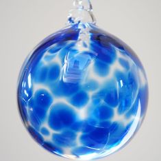 a blue glass ornament hanging from a chain