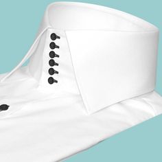 "High Spread Collar Shirt Tailor-Made On Order shirt 𝘈 𝘩𝘪𝘨𝘩 𝘤𝘰𝘭𝘭𝘢𝘳 𝘴𝘩𝘪𝘳𝘵 𝘪𝘴 𝘢 𝘤𝘭𝘢𝘴𝘴𝘪𝘤 𝘢𝘯𝘥 𝘵𝘪𝘮𝘦𝘭𝘦𝘴𝘴 𝘴𝘵𝘺𝘭𝘦 𝘵𝘩𝘢𝘵 𝘢𝘥𝘥𝘴 𝘢 𝘵𝘰𝘶𝘤𝘩 𝘰𝘧 𝘴𝘰𝘱𝘩𝘪𝘴𝘵𝘪𝘤𝘢𝘵𝘪𝘰𝘯 𝘵𝘰 𝘢𝘯𝘺 𝘰𝘶𝘵𝘧𝘪𝘵. 𝘛𝘩𝘪𝘴 𝘴𝘵𝘺𝘭𝘦 𝘧𝘦𝘢𝘵𝘶𝘳𝘦𝘴 𝘢 𝘤𝘰𝘭𝘭𝘢𝘳 𝘵𝘩𝘢𝘵 𝘴𝘵𝘢𝘯𝘥𝘴 𝘶𝘱 𝘢𝘯𝘥 𝘦𝘯𝘤𝘪𝘳𝘤𝘭𝘦𝘴 𝘵𝘩𝘦 𝘯𝘦𝘤𝘬, 𝘱𝘳𝘰𝘷𝘪𝘥𝘪𝘯𝘨 𝘢 𝘳𝘦𝘧𝘪𝘯𝘦𝘥 𝘢𝘯𝘥 𝘱𝘰𝘭𝘪𝘴𝘩𝘦𝘥 𝘭𝘰𝘰𝘬. 𝘐𝘵'𝘴 𝘢 𝘷𝘦𝘳𝘴𝘢𝘵𝘪𝘭𝘦 𝘱𝘪𝘦𝘤𝘦 𝘰𝘧 𝘤𝘭𝘰𝘵𝘩𝘪𝘯𝘨 𝘵𝘩𝘢𝘵 𝘤𝘢𝘯 𝘣𝘦 𝘸𝘰𝘳𝘯 𝘸𝘪𝘵𝘩 𝘢 𝘴𝘶𝘪𝘵 𝘧𝘰𝘳 𝘧𝘰𝘳𝘮𝘢𝘭 𝘰𝘤𝘤𝘢𝘴𝘪𝘰𝘯𝘴 𝘰𝘳 𝘥𝘳𝘦𝘴𝘴𝘦𝘥 𝘥𝘰𝘸𝘯 𝘸𝘪𝘵𝘩 𝘫𝘦𝘢𝘯𝘴 𝘧𝘰𝘳 𝘢 𝘤𝘢𝘴𝘶𝘢𝘭 𝘭𝘰𝘰𝘬. 𝘛𝘩𝘦 𝘩𝘪𝘨𝘩 𝘤𝘰𝘭𝘭𝘢𝘳 𝘢𝘭𝘴𝘰 𝘰𝘧𝘧𝘦𝘳𝘴 𝘢𝘥𝘥𝘪𝘵𝘪𝘰𝘯𝘢𝘭 𝘤𝘰𝘷𝘦𝘳𝘢𝘨𝘦 𝘢𝘯𝘥 𝘱𝘳𝘰𝘵𝘦𝘤𝘵𝘪𝘰𝘯 𝘢𝘨𝘢𝘪𝘯𝘴𝘵 Classic White Shirt With Covered Buttons, Classic White Fitted Collars, Formal Shirt With Covered Buttons, White Fitted Dress Shirt For Wedding, Fitted White Dress Shirt For Wedding, Classic White Wedding Tops, Classic White Wedding Top, Classic White Dress Shirt For Wedding, Classic Spread Collar Shirt For Wedding