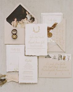 the wedding stationery is laid out on top of each other, including an envelope and ring