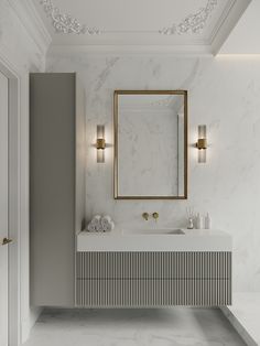 a bathroom with marble counter tops and gold framed mirror on the wall, along with two sinks