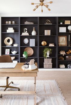 a living room filled with lots of bookshelves next to a desk and chair