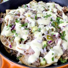 an image of mexican food being served in a skillet with sour cream on top