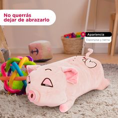 a stuffed pig laying on the floor next to toys and a sign that says no queras de abrazlo