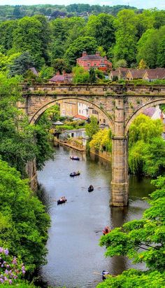 boats are on the water under an old bridge