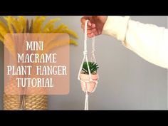 a person holding a plant hanger in front of a potted plant with the words mini macrame plant hanger