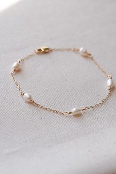 WHY YOU'LL LOVE IT This bracelet is so special and meaningful. This is a perfect gift for a loved one or for yourself. Pearls radiate simple elegance, perfect for any occasion or outfit.      Note: Each bracelet, regardless of the size will have five pearls spread out roughly 3/4 inch apart.  MATERIALS -Genuine Fresh Water Pearls -All materials are 14kt Gold-Filled including; dainty paperclip chain, jump rings, lobster clasp and wire. DETAILS -Hypoallergenic, great for sensitive skin  -Non-Tarni Elegant Personalized Pearl Bracelet For Everyday, Elegant Everyday Personalized Pearl Bracelet, Delicate 14k Gold Filled Bracelet For Gift, Delicate 14k Gold Filled Bracelet As Gift, Elegant Gold Bracelet For Wedding And Mother's Day, Classic Bracelet Jewelry For Mother's Day, Dainty Gold Bracelet For Wedding And Mother's Day, Classic Rose Gold Pearl Bracelet As Gift, Classic Rose Gold Pearl Bracelet Gift