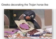 a penguin holding a piece of paper with the caption greek decorating the iron horse like