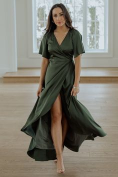 a woman in a green dress is standing on the floor with her legs spread out