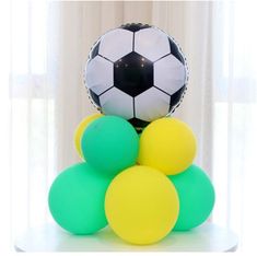 a bunch of balloons are stacked on top of each other in front of a soccer ball