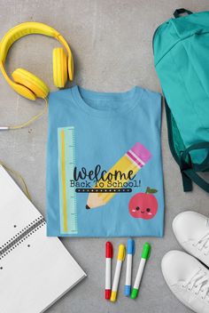 a blue shirt with the words welcome back to school next to headphones and other items