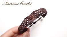 a hand holding a brown crochet bracelet