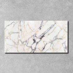 a white and black marble wall mounted on the side of a gray concrete wall,