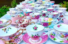 a table topped with lots of colorful cups and saucers