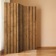 an empty room with wood paneling on the walls and wooden floors in front of a window