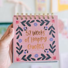 a pink notebook with the words 52 weeks of happy quotes written on it