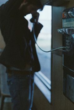 a man is talking on the phone while standing in front of an electrical box with a quote