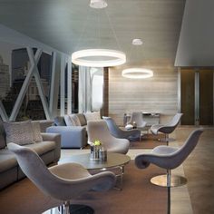 a living room filled with lots of furniture next to a window covered in glass walls