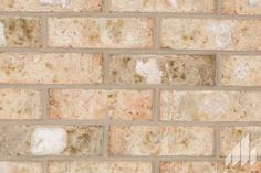 a brick wall with brown and white stains on the bricks, as seen from above