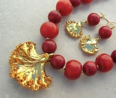 "Please read the entire description.  Here's a really unique autumn necklace. These beautiful leaves are real curly cabbage (kale) leaves with a heavy 22K gold coating. I think they are gorgeous. The leaves are reflecting some red in the photos but actually have just a touch of red. The larger crimson beads are very old resin beads from Yemen. The smaller beads are dyed jade. The jade is a bit heavy but the resin is very lightweight. The tiny beads are brass seed beads. The S-hook clasp and the Autumn Necklace, Cabbage Leaves, Resin Beads, Leaf Necklace, Jade Beads, Beads Necklace, Real Gold, Matching Earrings, Beautiful Bracelet