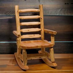 a wooden rocking chair sitting on top of a hard wood floor next to a wall