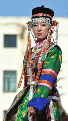 a woman dressed in colorful clothing riding on the back of a horse