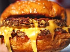 a close up of a hamburger with cheese on it