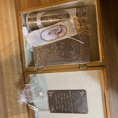 an open wooden box containing two silver items and a plaque with writing on the inside