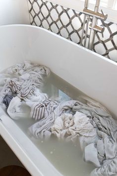 a bathtub filled with lots of dirty towels