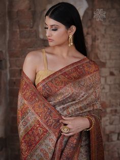 Beige Kani saree in silk fabric is accentuated with Kani weaving over the borders and pallu in traditional motifs like paisleys and flowers in subtle colours. Contrast border and pallu add a dash of colour and a touch of zari thread adds a hint of shine to this gorgeous saree. It is accompanied with Kani booti blouse piece in contrasting colour. The design inspiration for this Pashmina Silk saree is drawn from the heritage weaves of ancient Pashmina shawls from our history that dates back to the Luxury Traditional Wear For Ceremonies With Pallu, Luxury Elegant Saree With Pallu, Luxury Bollywood Style Silk Shawl, Luxury Pashmina Saree With Traditional Drape, Luxury Bohemian Pashmina Saree, Luxury Zari Weaving Dupatta For Transitional Season, Luxury Bollywood Katan Silk Shawl, Luxury Chinon Saree With Pallu Detail, Luxury Traditional Katan Silk Shawl