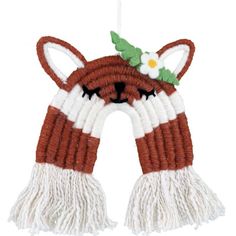 a brown and white cat ornament hanging from a string with flowers on it