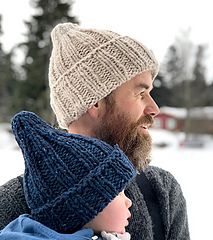 a man holding a baby wearing a knitted hat