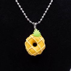 a necklace with a yellow and green pineapple on it